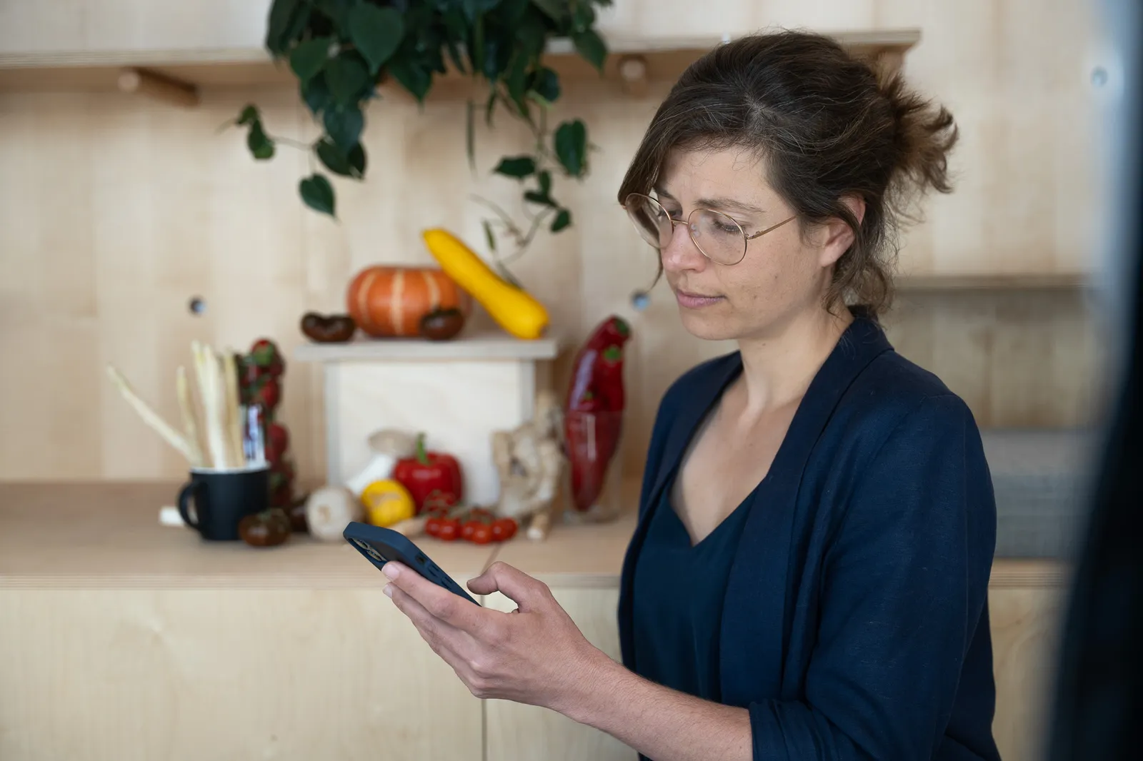 A person using their phone in a kitchen
